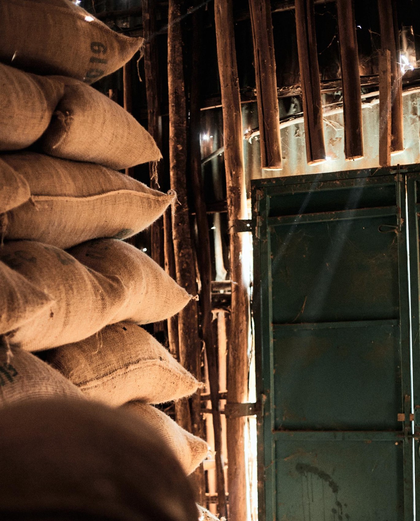 Stacked burlap sacks of green coffee at origin