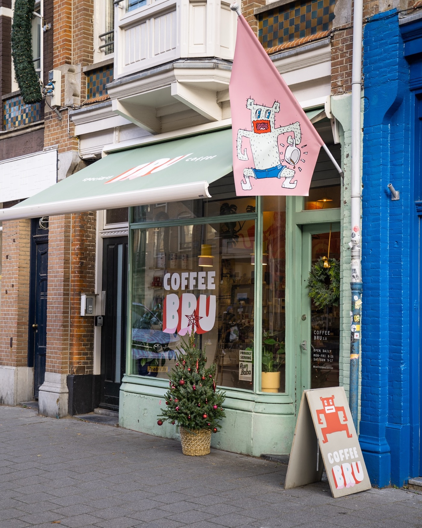The green fronted Coffee Bru storefront on Beukenplein, a small Christmas tree and sandwich board out front