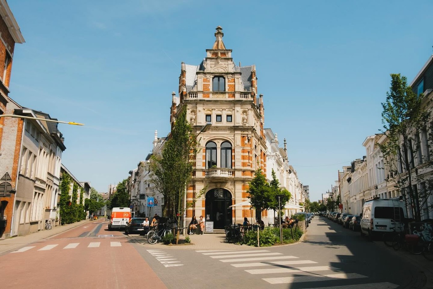 The ornate corner building housing Rush Rush Cafe in Zurenborg, with outdoor tables along the sidewalk