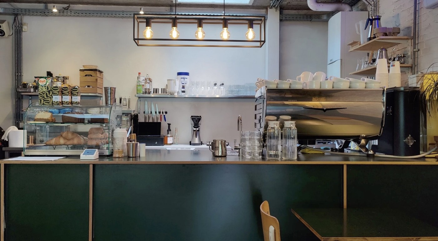 The espresso bar counter at Viggo's, with a pastry case, glassware, and an industrial pendant light overhead