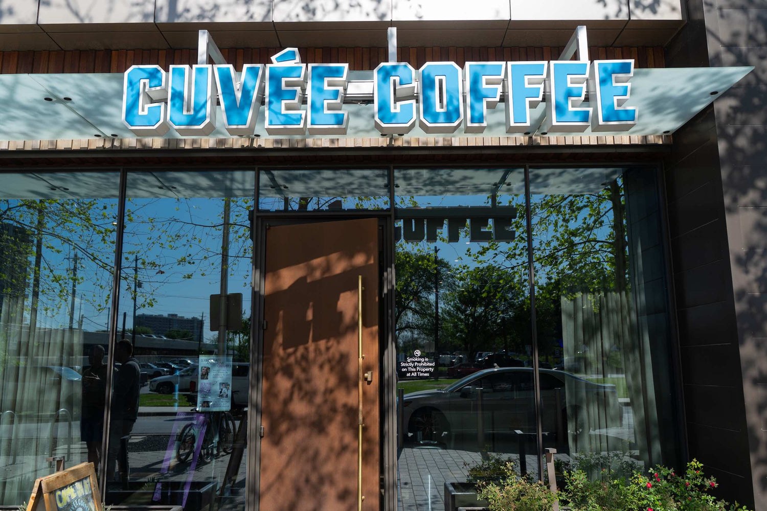 The branded Cuvée Coffee storefront sign above a glass entrance