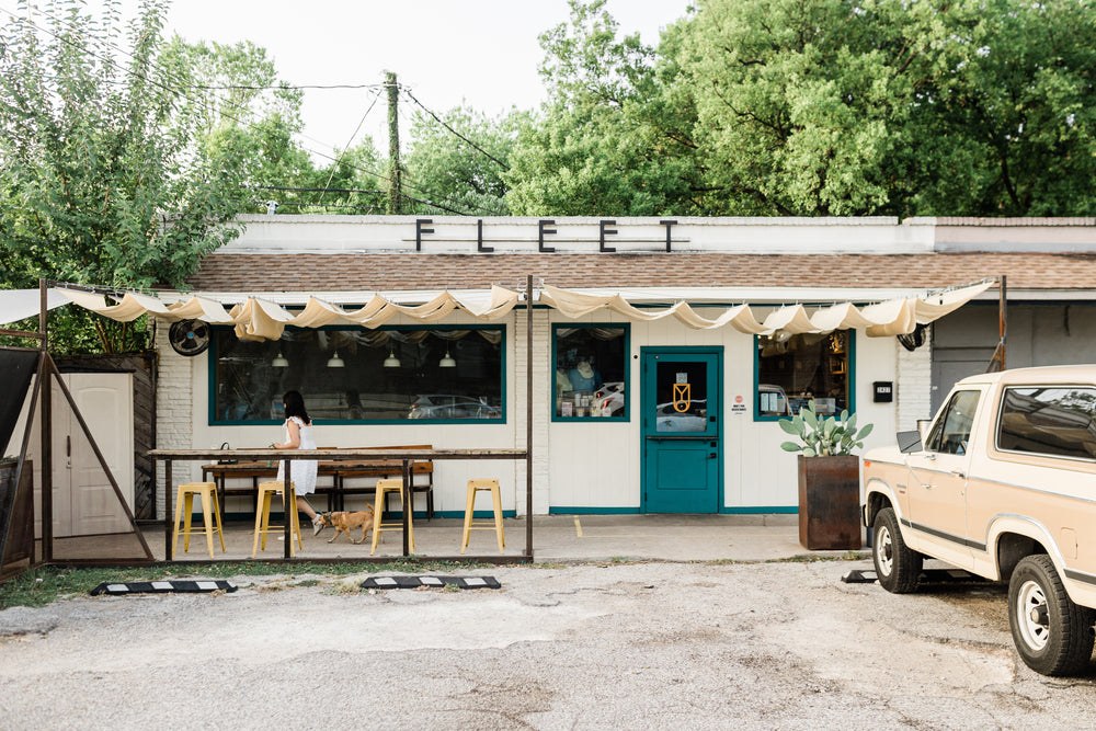 The FLEET storefront sign and teal door at the Webberville Road cafe