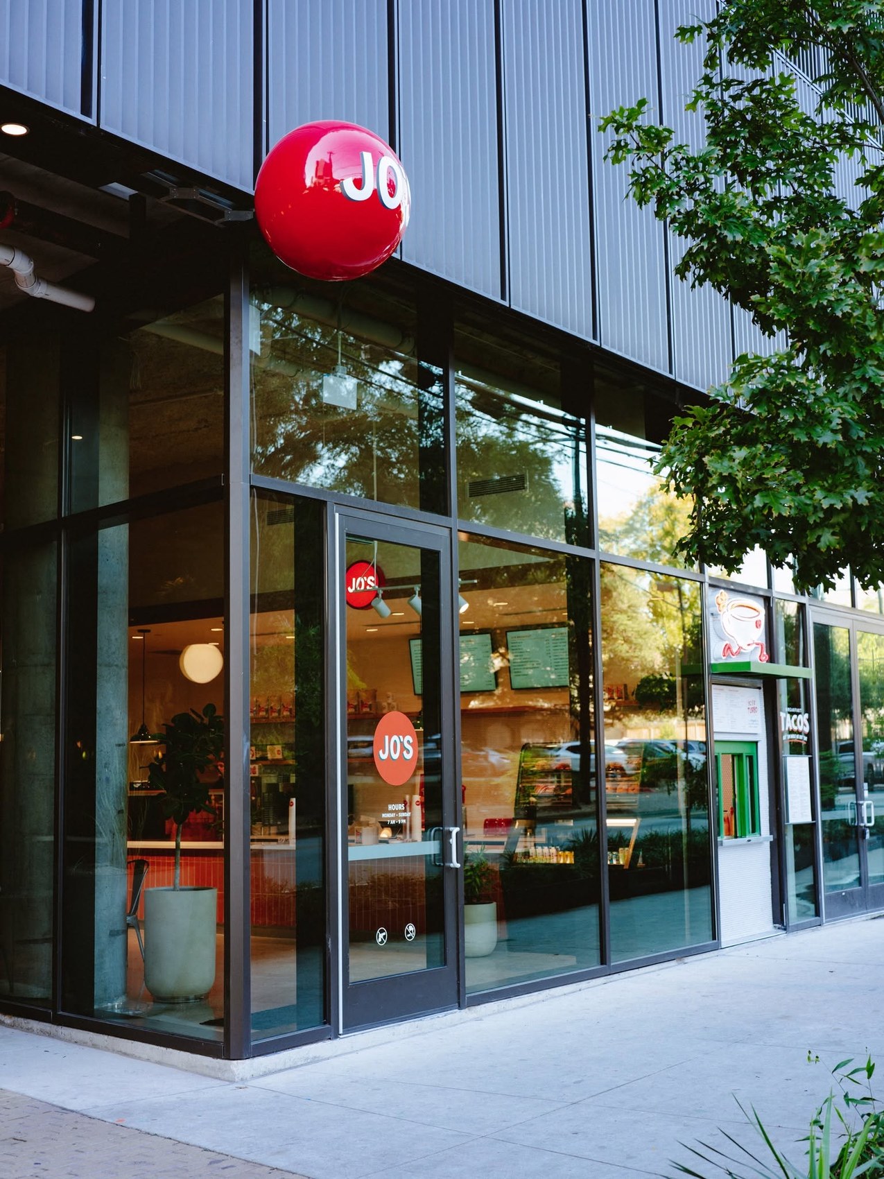 The modern glass storefront with the branded red Jo's ball sign