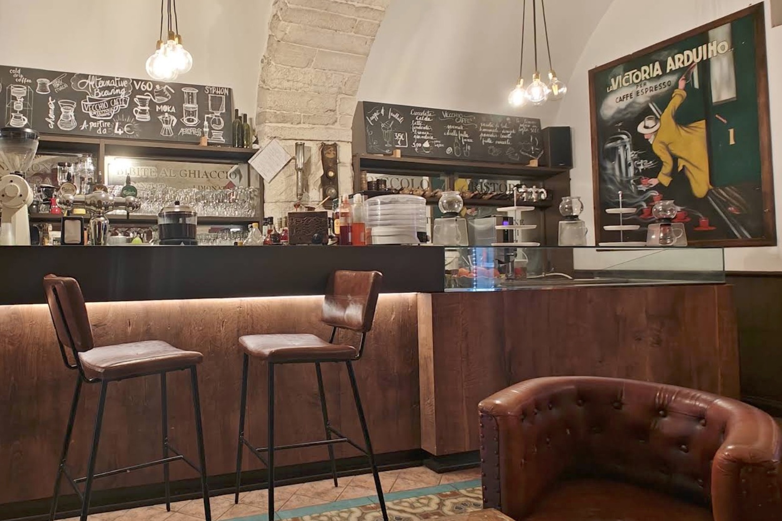 The bar counter at Vecchio Caffè with hand lettered brew method chalkboards and a vintage La Victoria Arduino poster on the wall