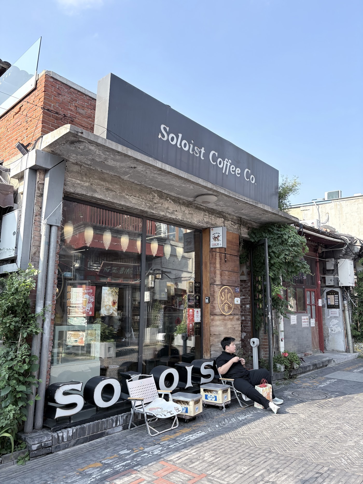 The brick and timber Soloist Coffee Co. storefront on Yangmeizhu Xiejie, with large SOLOIST letters set on the sidewalk out front