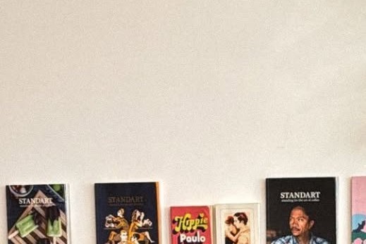 A wooden shelf at Spontan holding several issues of Standart coffee magazine and a Paulo Coelho paperback