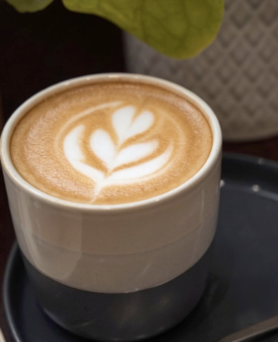 A close overhead view of a latte with tulip latte art in a stoneware cup at Melée Café
