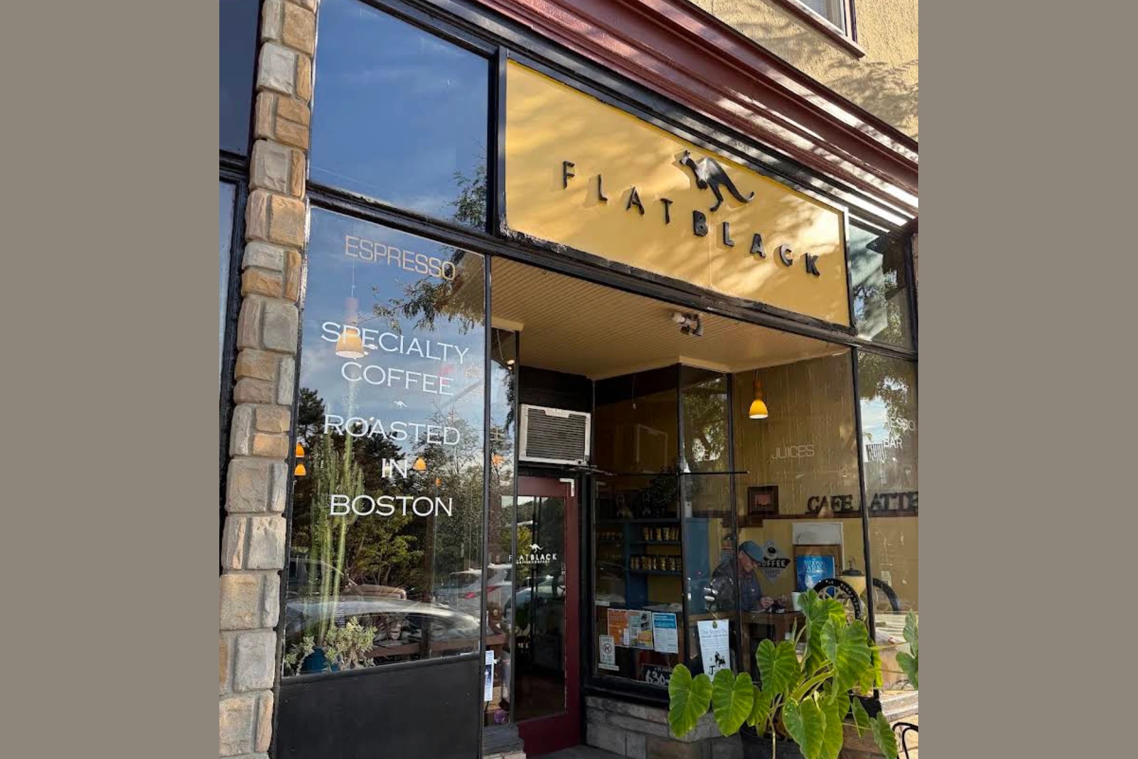 The FLATBLACK sign above the storefront, with Specialty Coffee Roasted in Boston lettered on the window