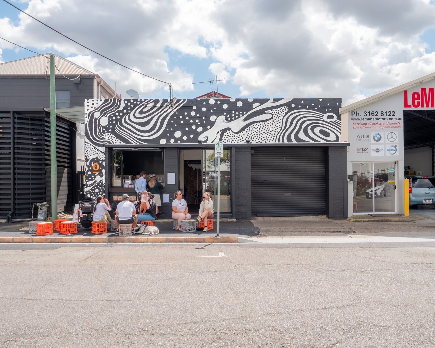 The black and white mural-fronted Single O Newstead shopfront with customers seated at outdoor tables