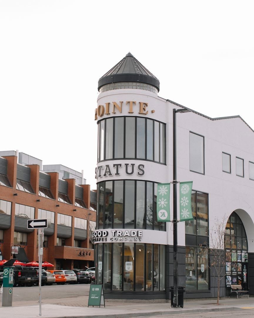 The rounded corner tower of the building housing Good Trade Coffee Company, with GOOD TRADE COFFEE COMPANY lettered above the entrance