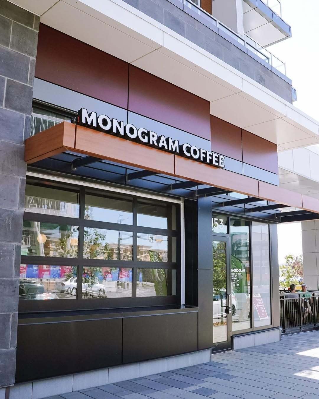 The storefront awning with an illuminated MONOGRAM COFFEE sign above the glass entrance and street level windows