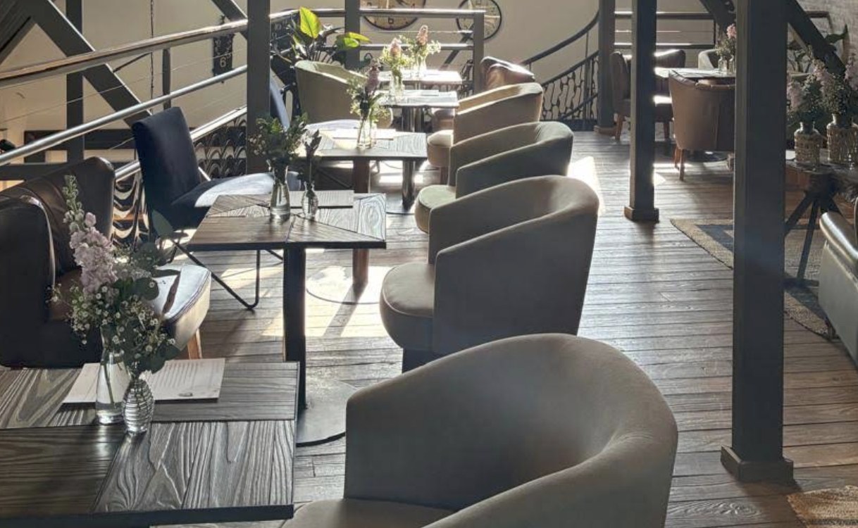 The upstairs lounge seating area at COR Café, with plush chairs and fresh flowers