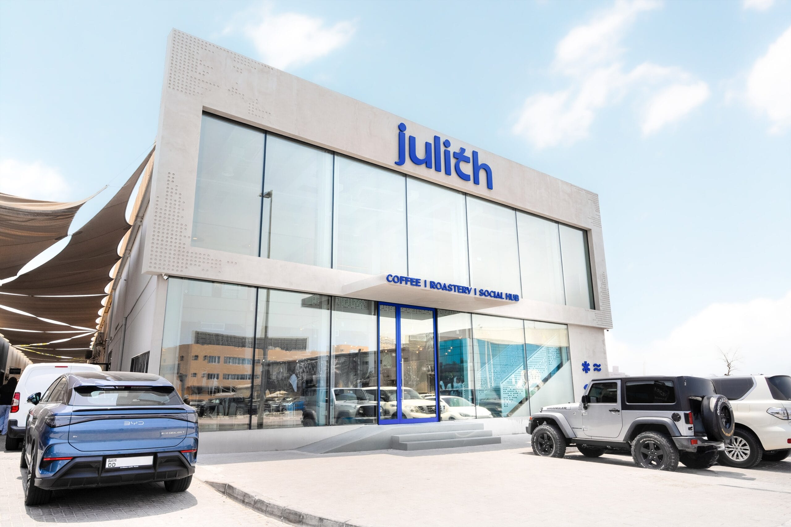 The two storey concrete and glass Julith building in Al Quoz with its blue wordmark and the sign reading Coffee, Roastery, Social Hub