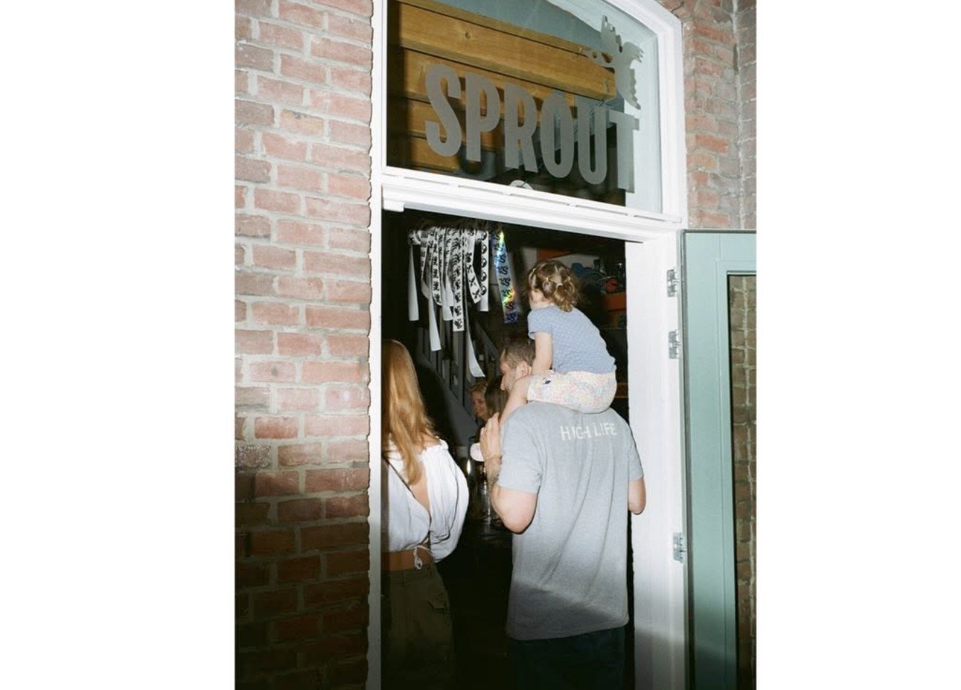 The brick archway entrance with the SPROUT sign overhead, visitors filing in through the door
