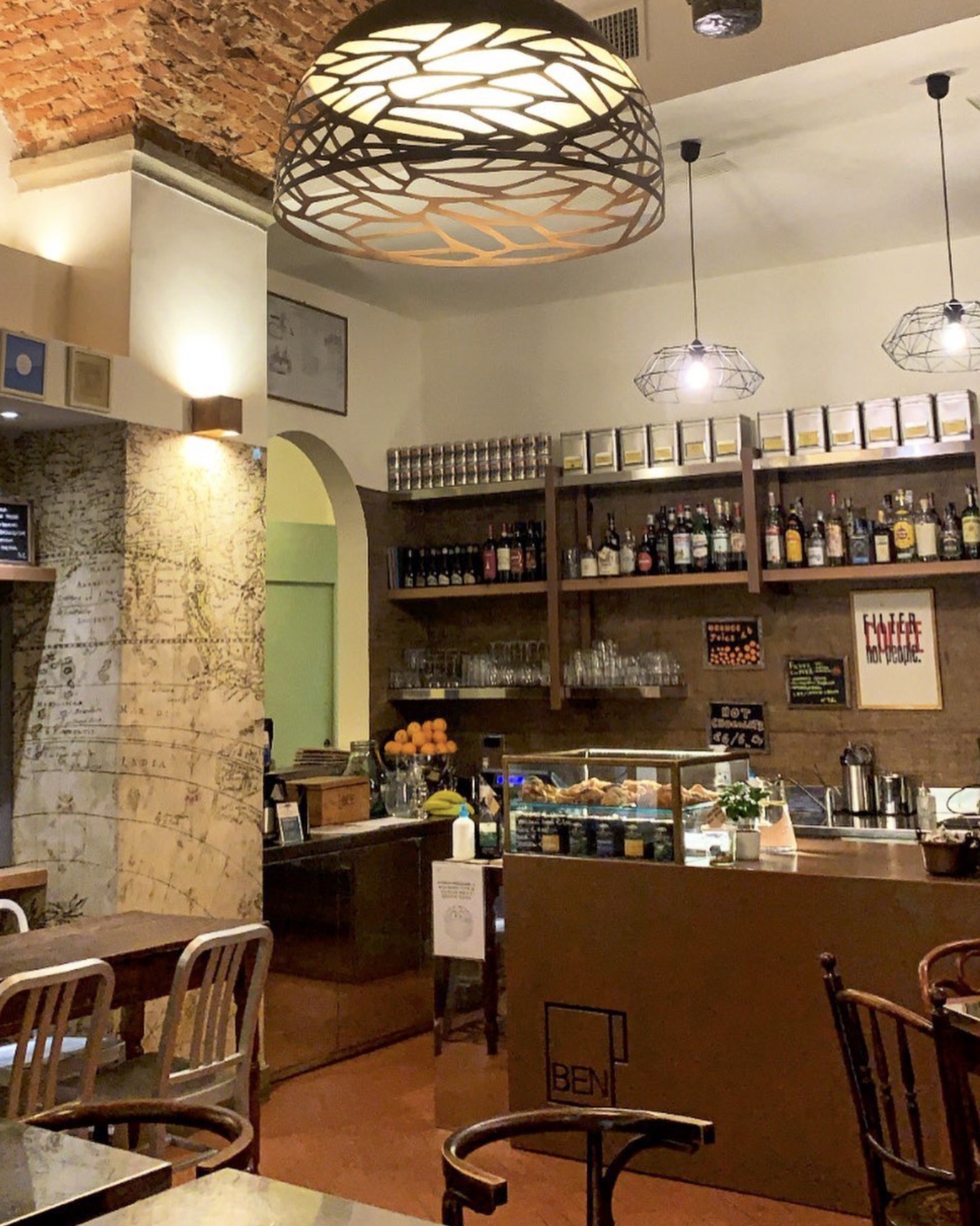 The Ben Caffè counter under a brick vaulted ceiling, with a Filter Coffee Not People sign and pastry case behind the bar