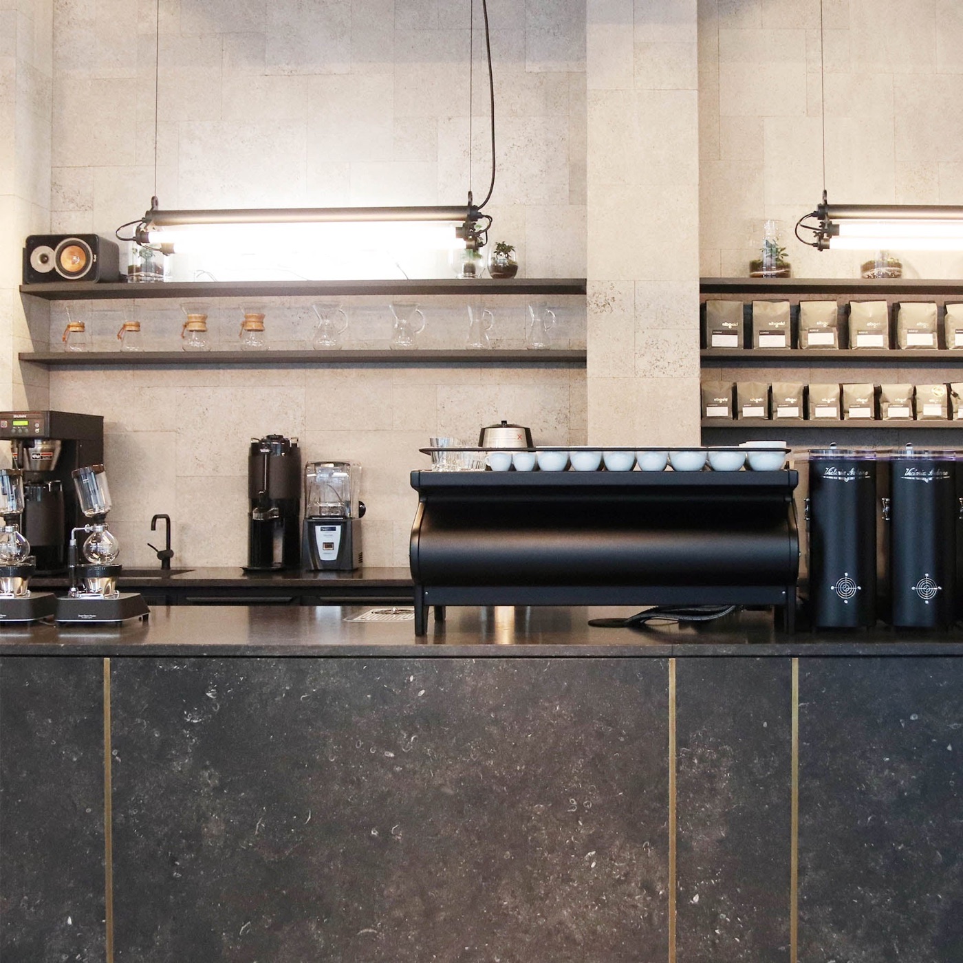 The espresso bar at Elbgold with branded coffee bags on open shelving and rows of Chemex carafes