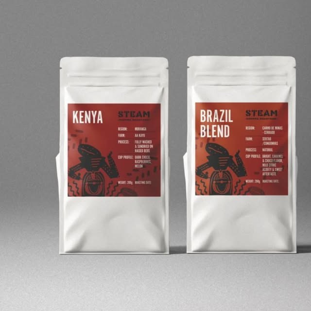 Two retail bags of Steam coffee, labeled Kenya and Brazil Blend, on a plain grey background