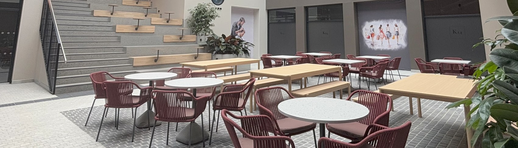 The shared K14 courtyard seating area with tiered wooden steps and cafe tables