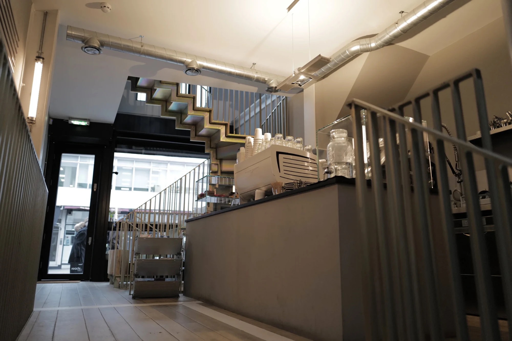 The espresso counter at LIFT Coffee's Kensington shop, with its distinctive iridescent staircase and exposed ductwork behind