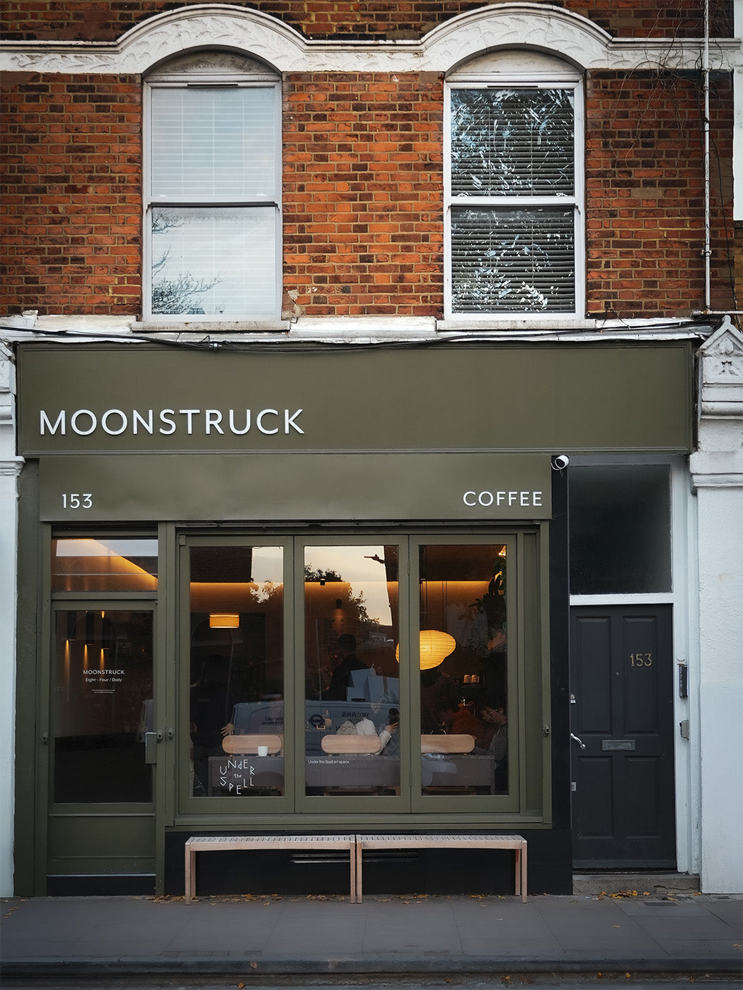 The olive green Moonstruck storefront at 153 South Lambeth Road, warmly lit windows showing the room inside
