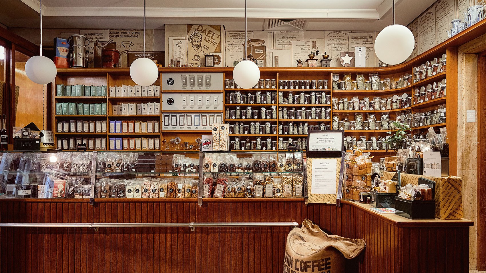 The historic Wolfstraat retail shop's wood shelving lined with jars of tea and coffee, chocolates and sweets in the counter case below