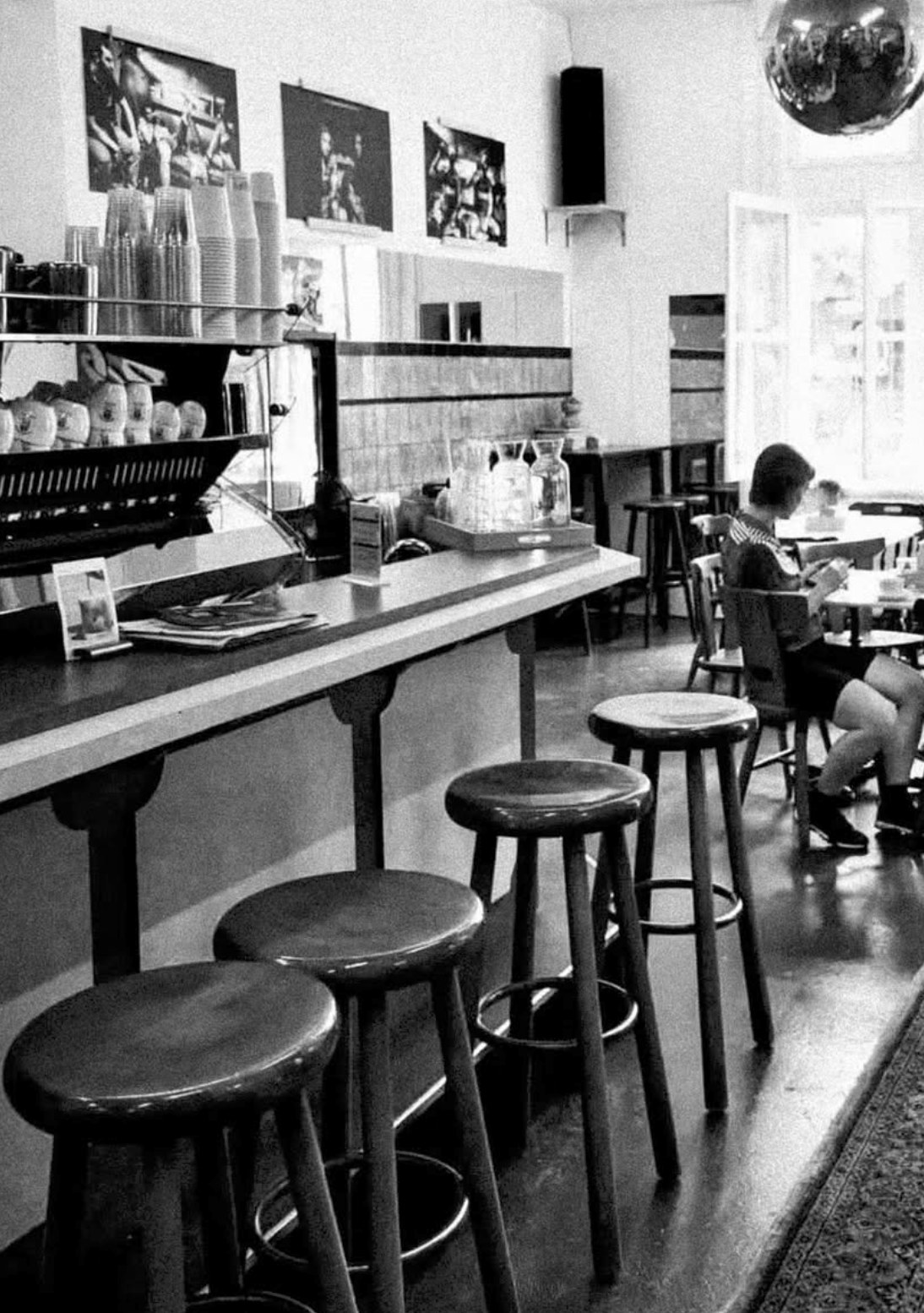 Bar stool seating along the counter at Fixed Gear Coffee's Wyck location, in black and white