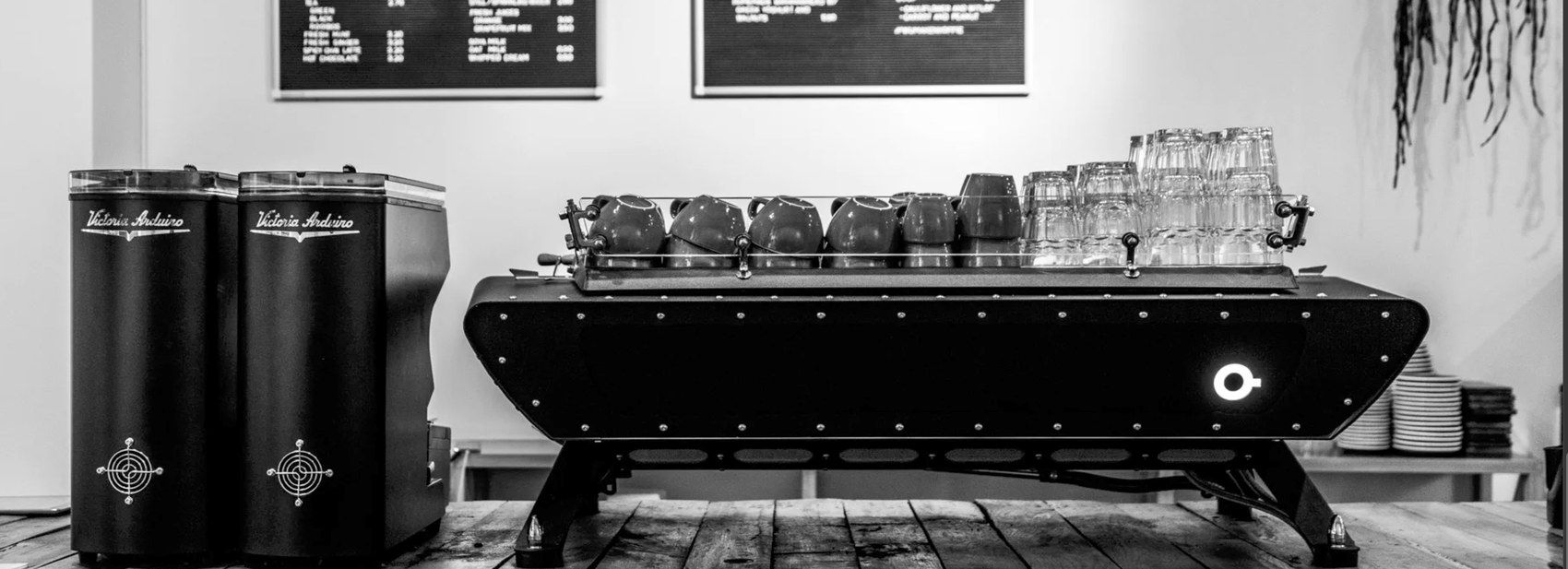 Espresso machine and grinders on the counter at KOFFIE bij Joost en Maartje, in black and white