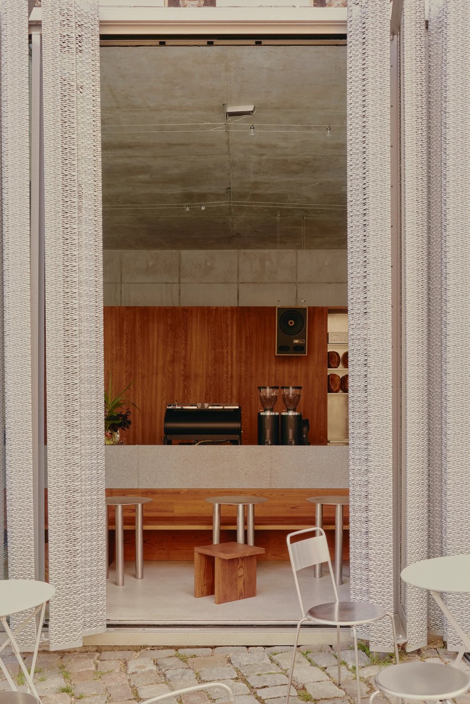 Looking through Acid Cafe's woven doorway into the concrete-and-wood counter inside