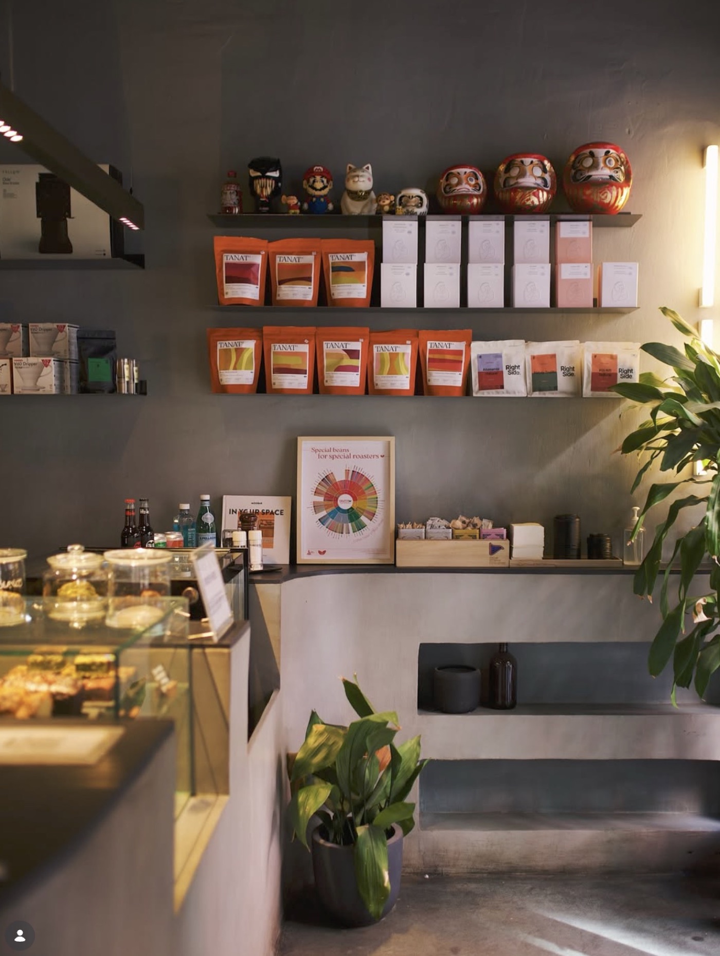 Retail shelves at HanSo Cafe stocked with bagged coffee, ceramics, and a pastry case below