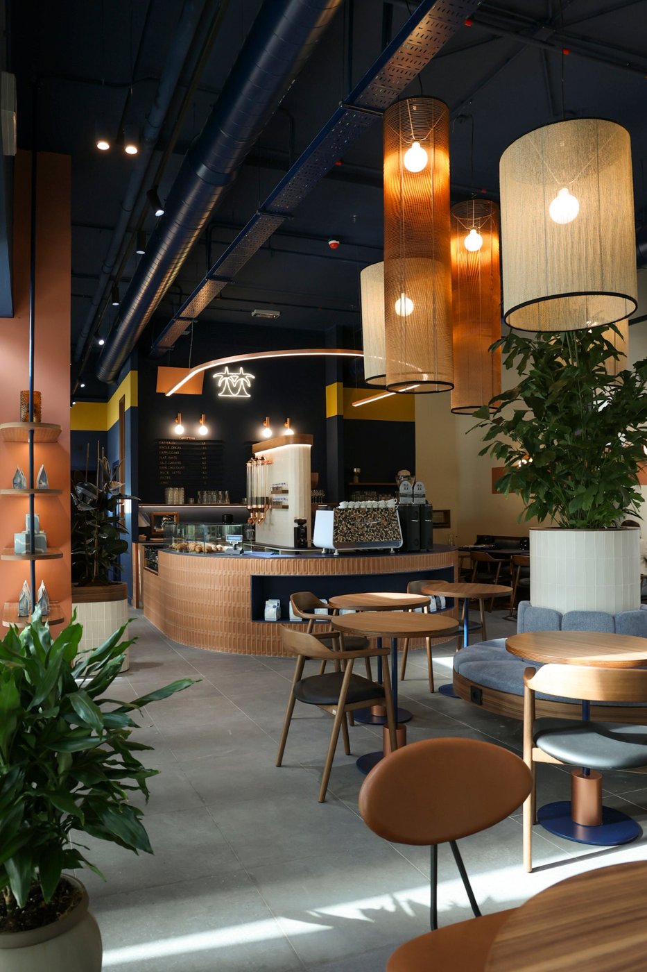 Inside Cafezal, a curved wood-clad counter under woven pendant lamps in the Brera flagship