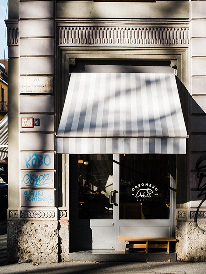 The Orsonero Coffee storefront in Porta Venezia, striped awning and bear-logo signage on the glass door