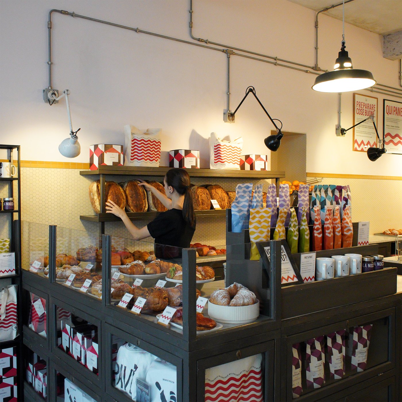 The bakery counter at Pave, pastries and bread on display beneath hanging lamps
