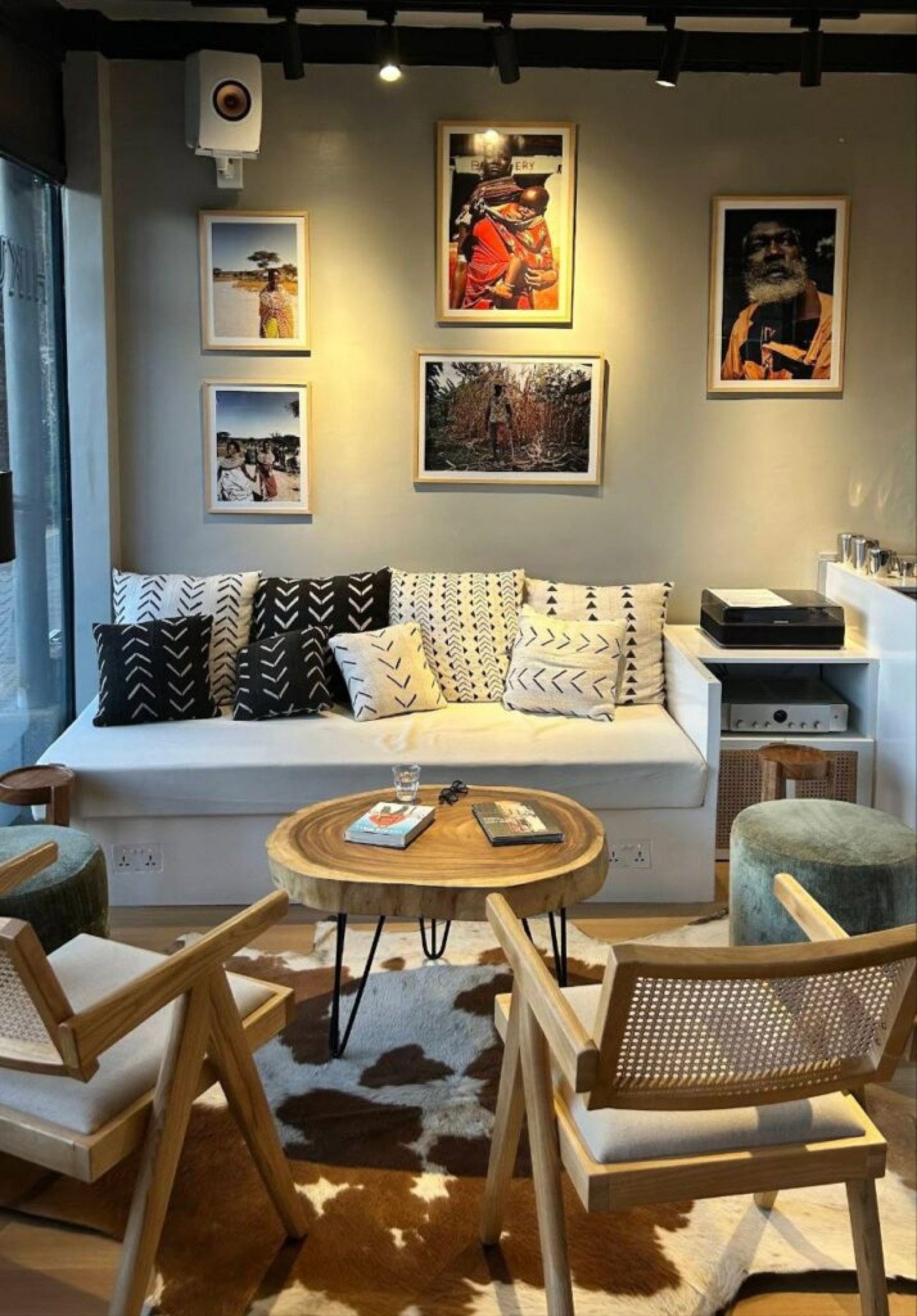 The lounge seating at Hikuri Coffee, mud cloth pillows on a white daybed and cane chairs around a live edge table
