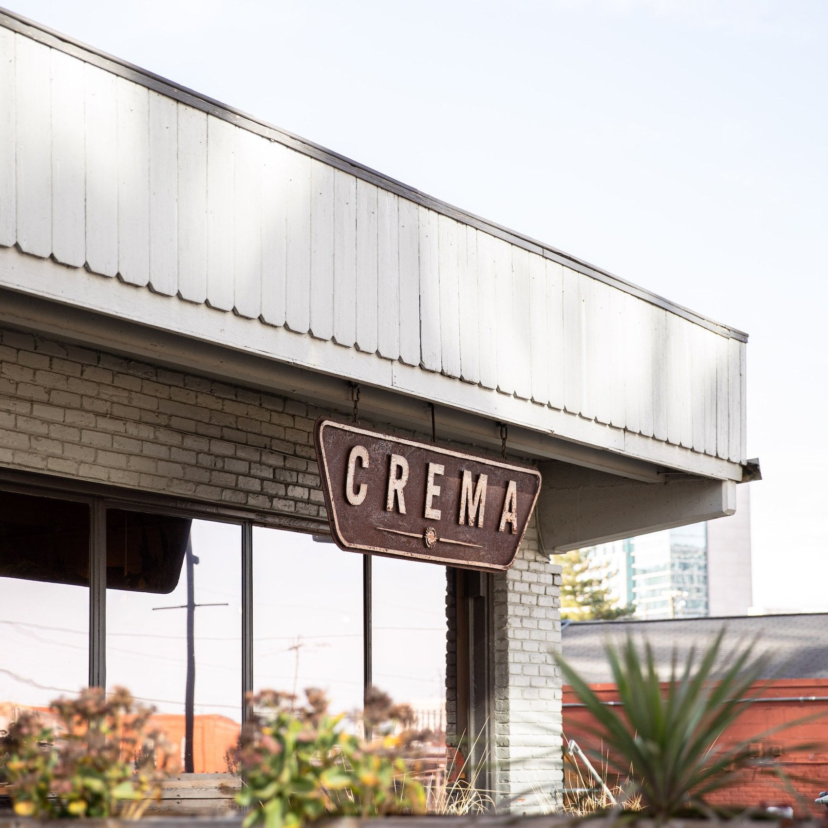 The vintage Crema sign hanging beneath the building's eave