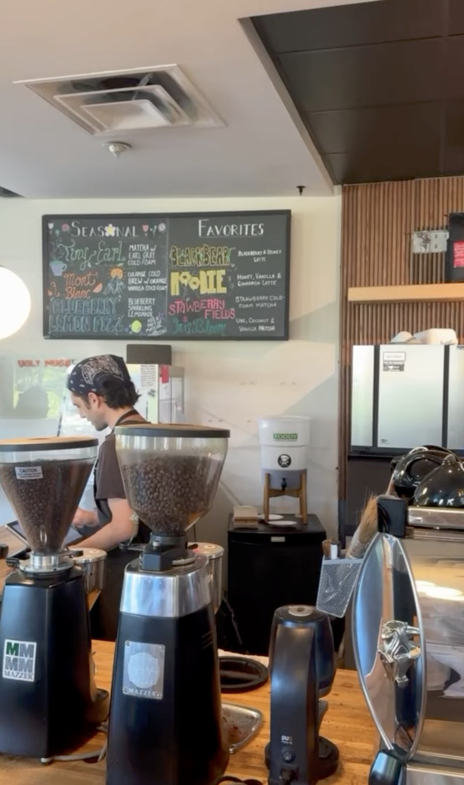 The hand lettered seasonal drinks chalkboard behind the grinders at Ugly Mugs Coffee & Tea
