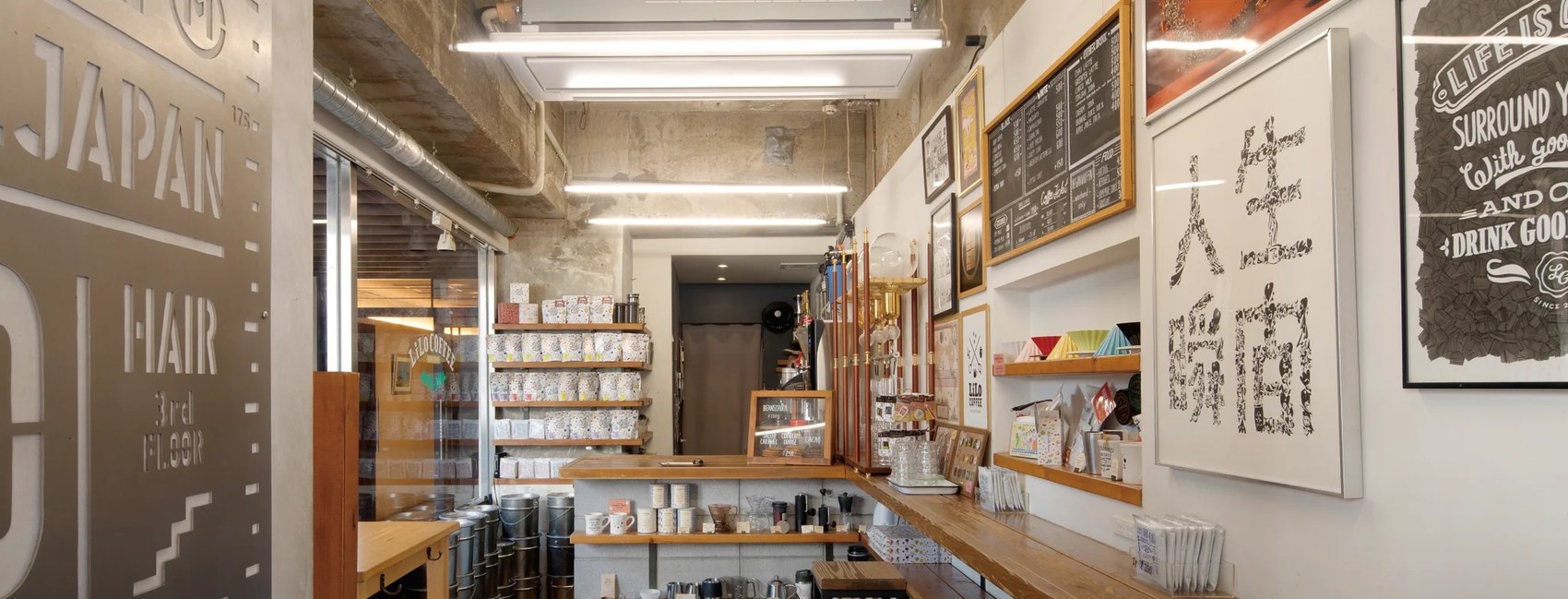 The LiLo Coffee Roasters counter with shelves of bagged beans, framed artwork and a bar built into a raw concrete space
