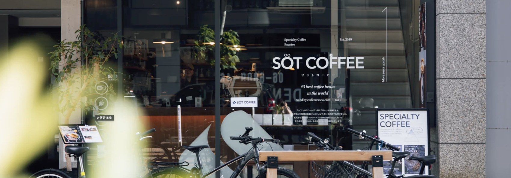 The SOT Coffee Roaster storefront with the shop name lettered on the window and bicycles parked out front