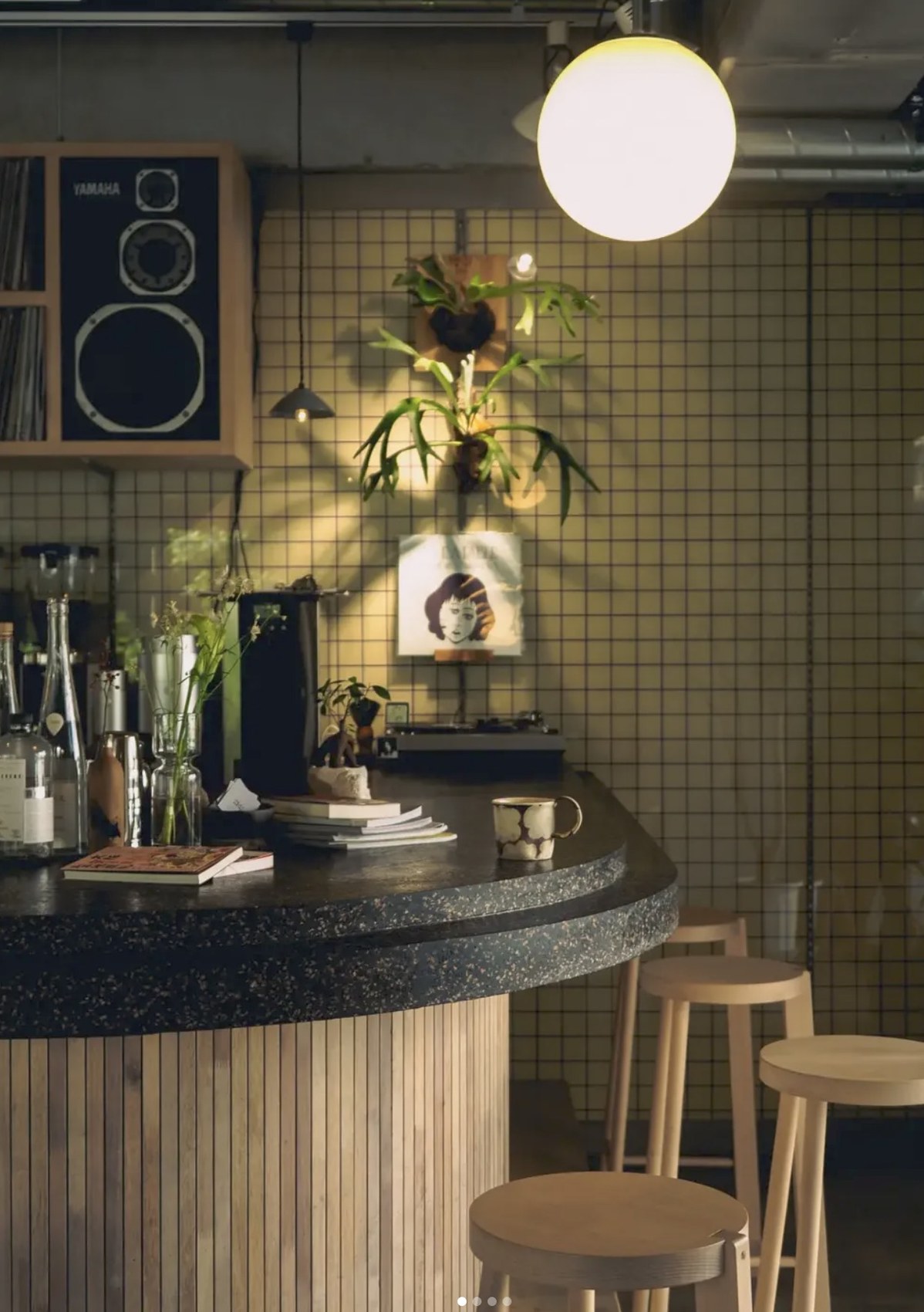 The curved terrazzo counter at Ue. Coffee with gin and wine bottles, a record player and a wall of green tile behind