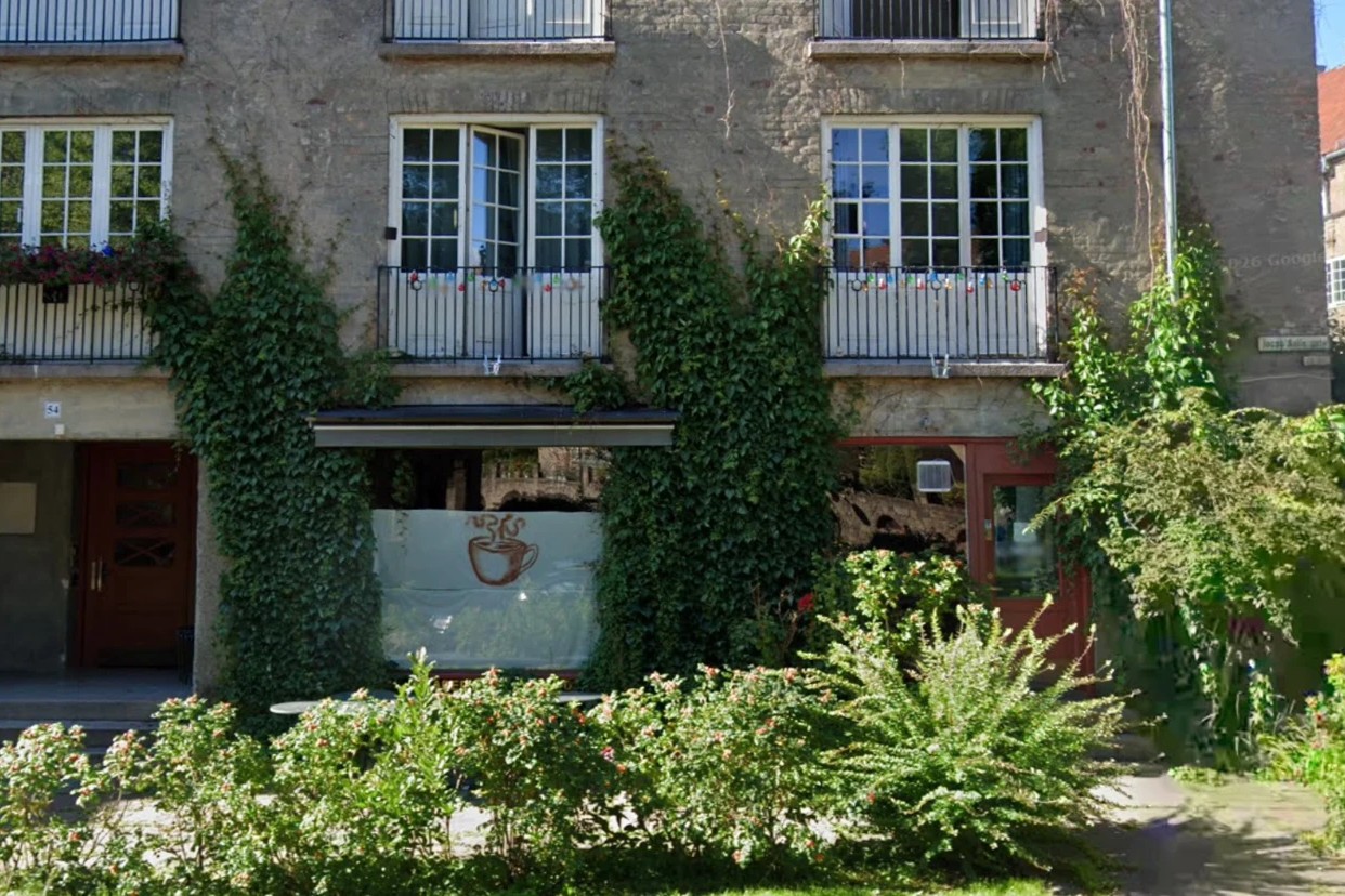 The ivy covered facade of Havens Kafe's building at Jacob Aalls gate 54, with a hand drawn coffee cup on the frosted front window
