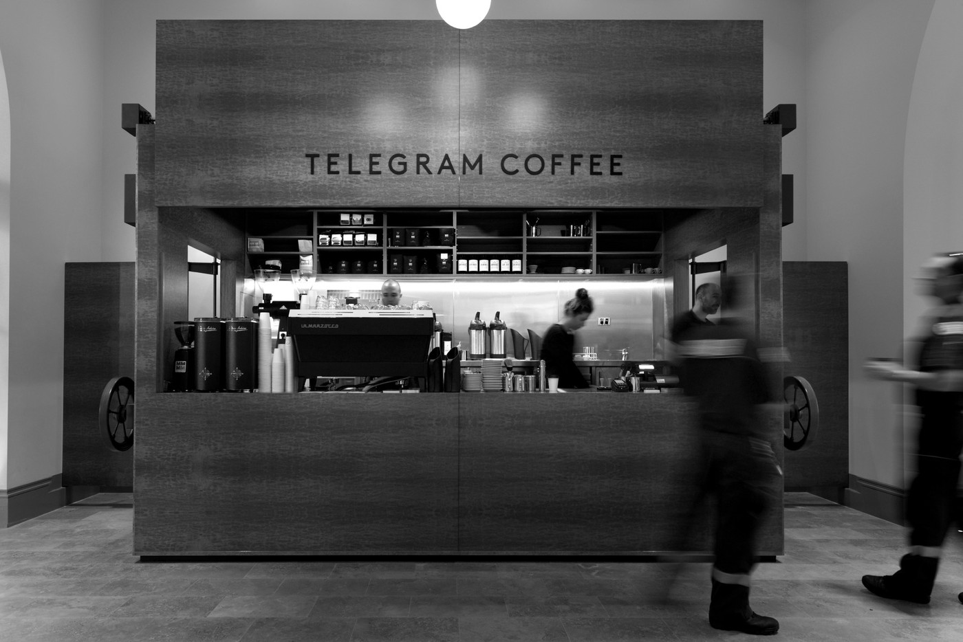 The Telegram Coffee kiosk with its restored crank wheels and La Marzocco machine, staff working the counter inside the State Buildings