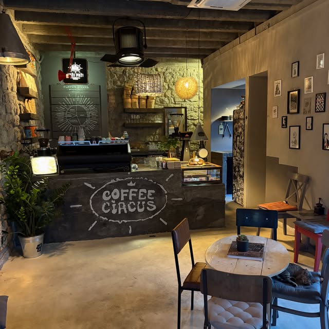 The rustic stone walled interior of Coffee Circus Drzi Przi with a chalk lettered counter sign