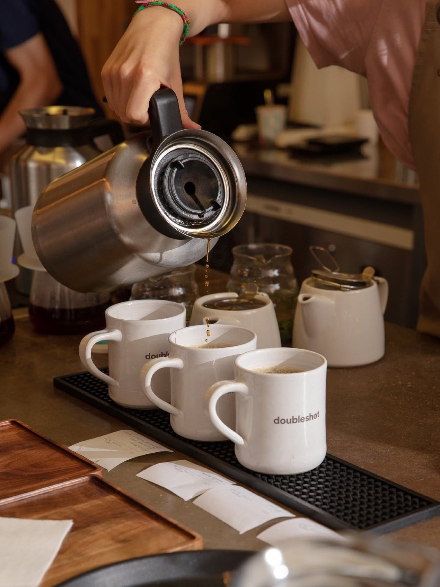 A batch of filter coffee poured into branded Doubleshot mugs lined up on the counter
