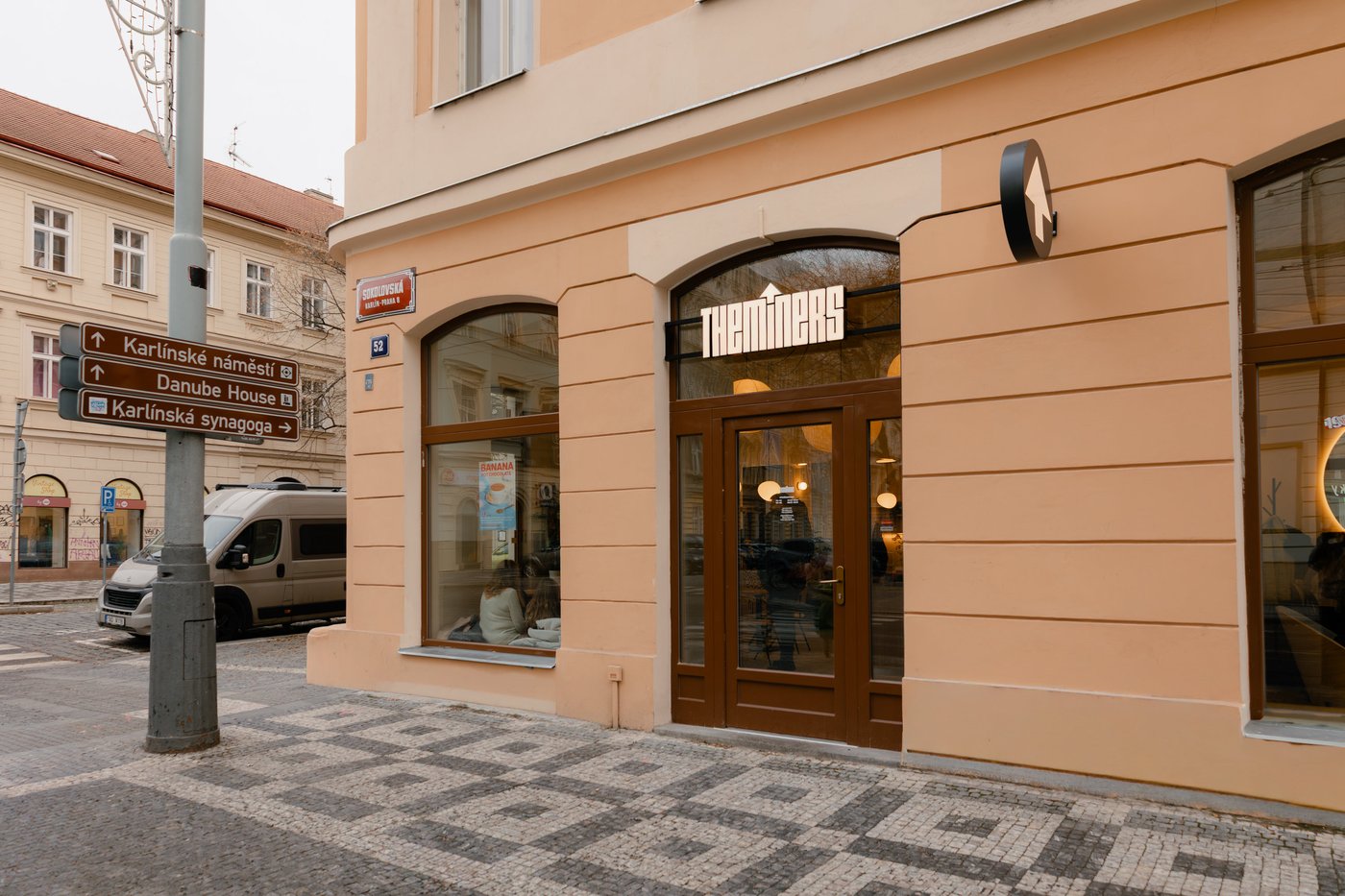 The Miners Karlin storefront on a Sokolovska street corner with an illuminated sign over the entrance