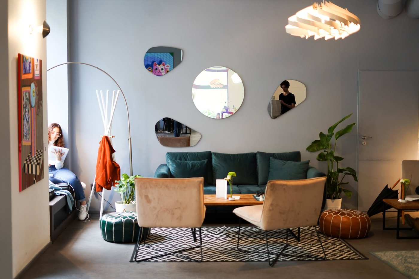 A green velvet sofa, low armchairs and a wall of mismatched mirrors in the lounge like interior of Version Coffee
