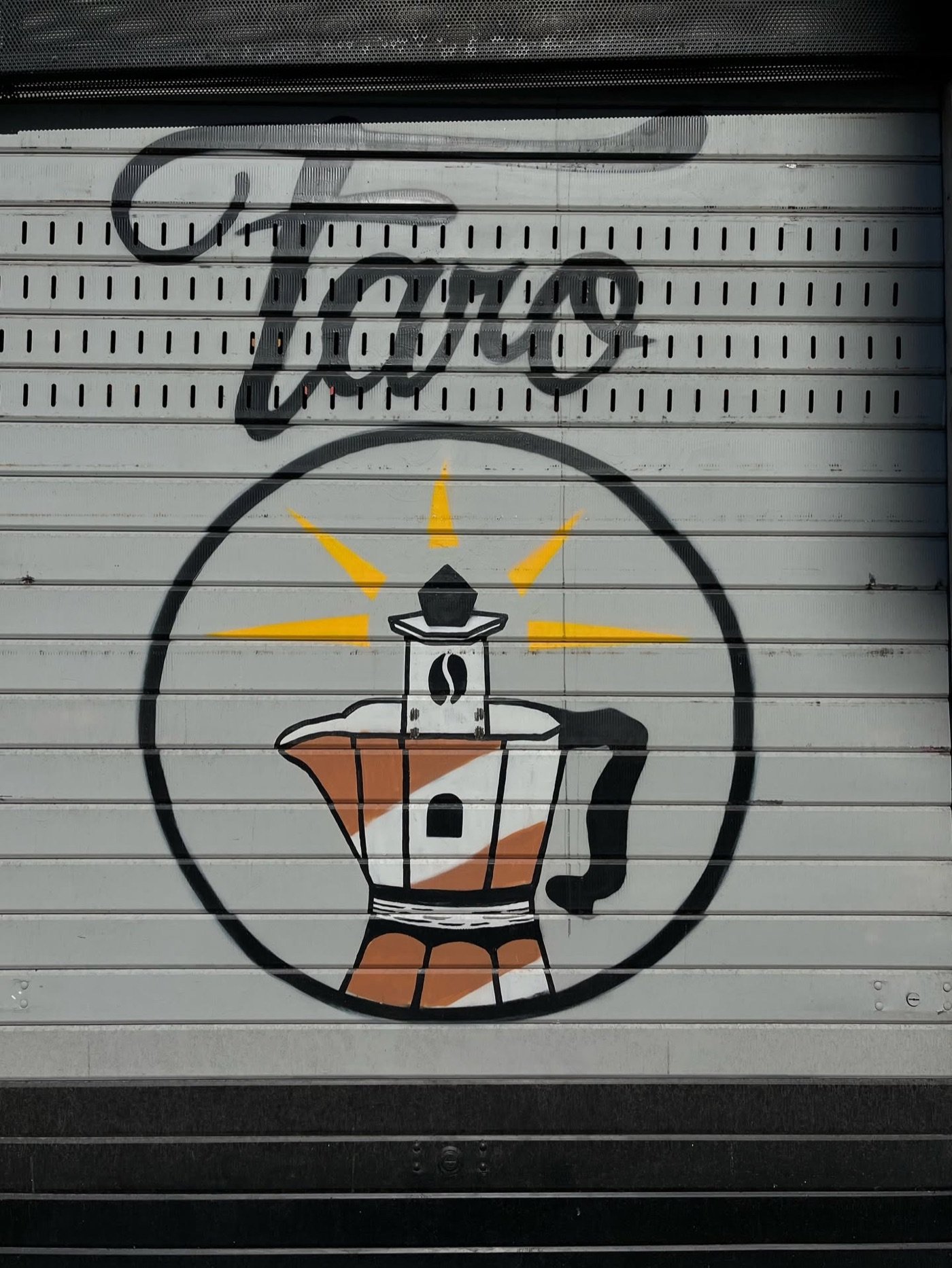 The Faro lighthouse and moka pot logo painted on the shop's rolling shutter
