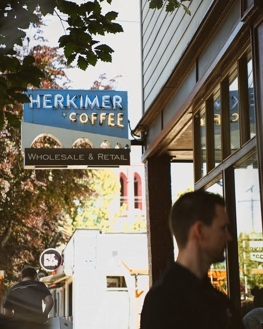 The lit Herkimer Coffee sidewalk sign outside the storefront