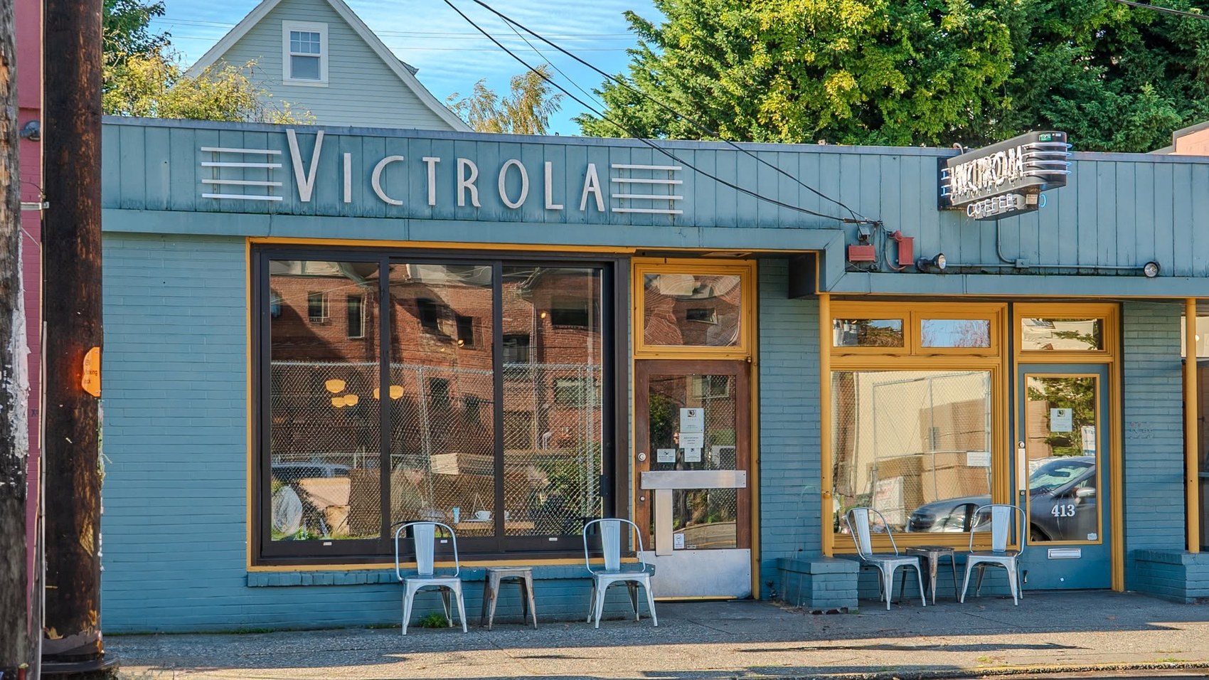 The Pike Street storefront at Victrola Coffee Roasters with the Victrola sign and outdoor seating