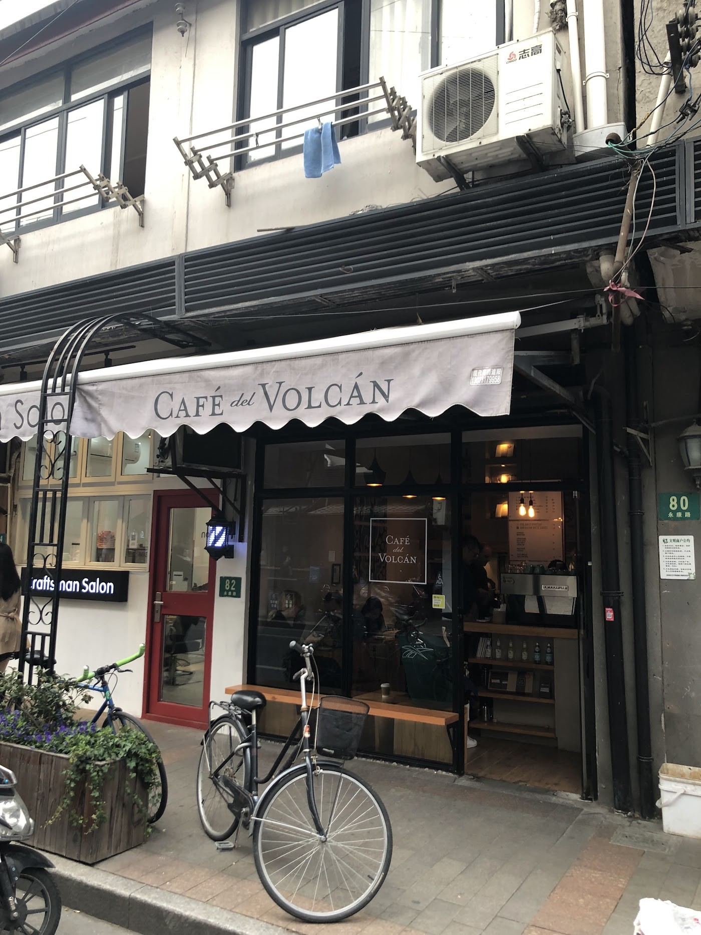 The Café del Volcán awning above the glass storefront on Yongkang Road, a bicycle parked out front