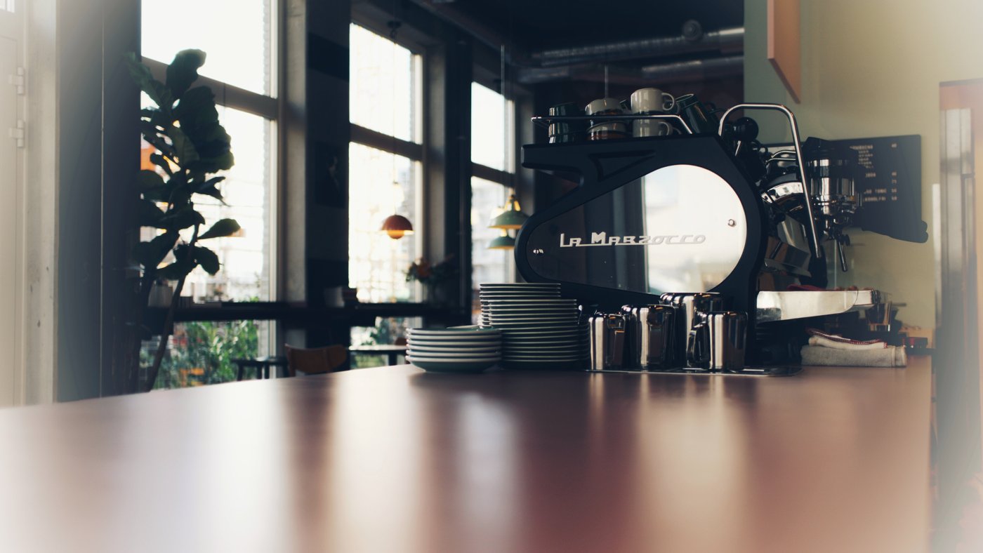The La Marzocco espresso machine on the counter at Muttley & Jack's, plants and big windows behind