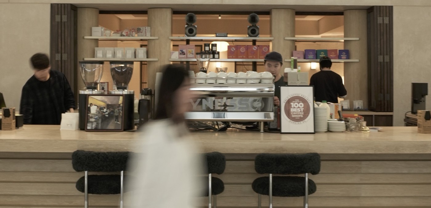 The Synesso espresso machine and retail bean shelves at Only Coffee Project, with a framed World's 100 Best Coffee Shops ranking on the counter